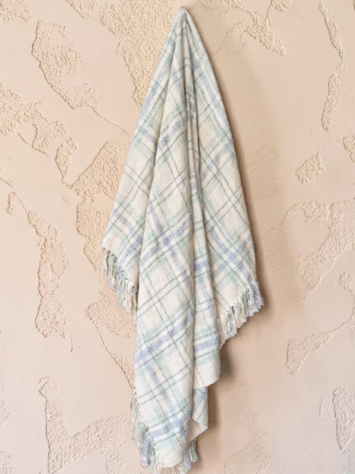 "Green Pastures" woven throw blanket in sage green, hanging display
