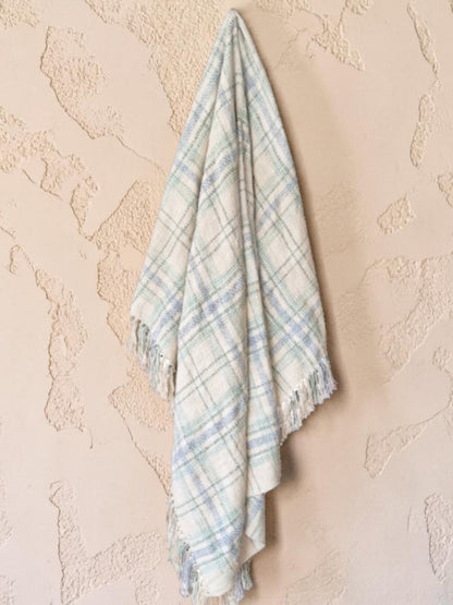 "Green Pastures" woven throw blanket in sage green, hanging display