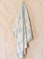 "Green Pastures" woven throw blanket in sage green, hanging display